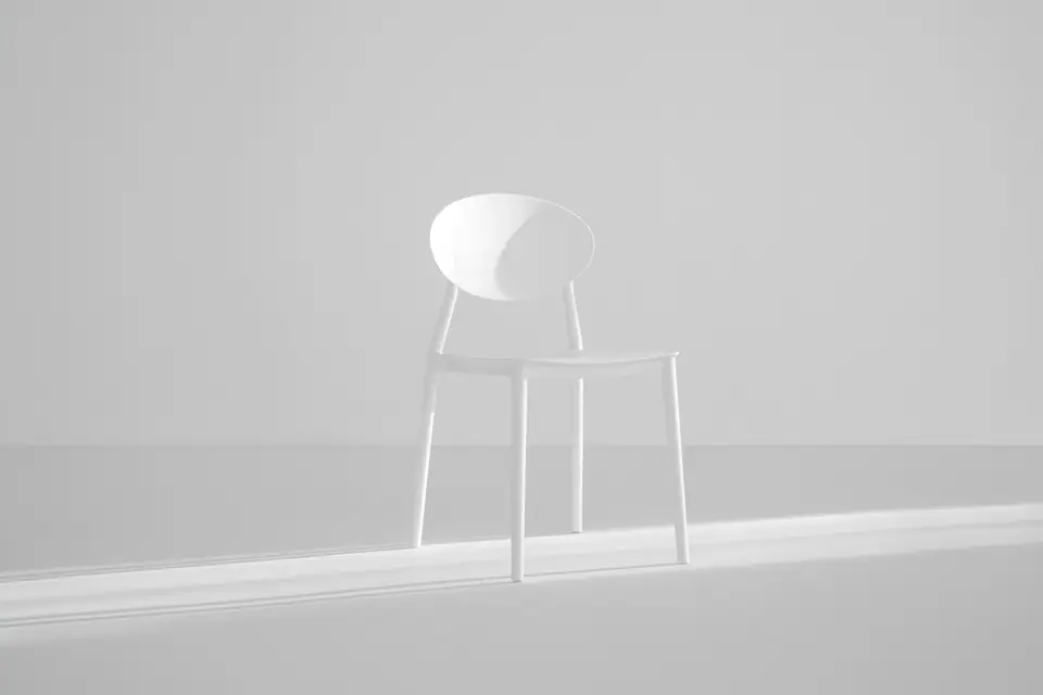 Original white metal chair in front of a light-grey wall